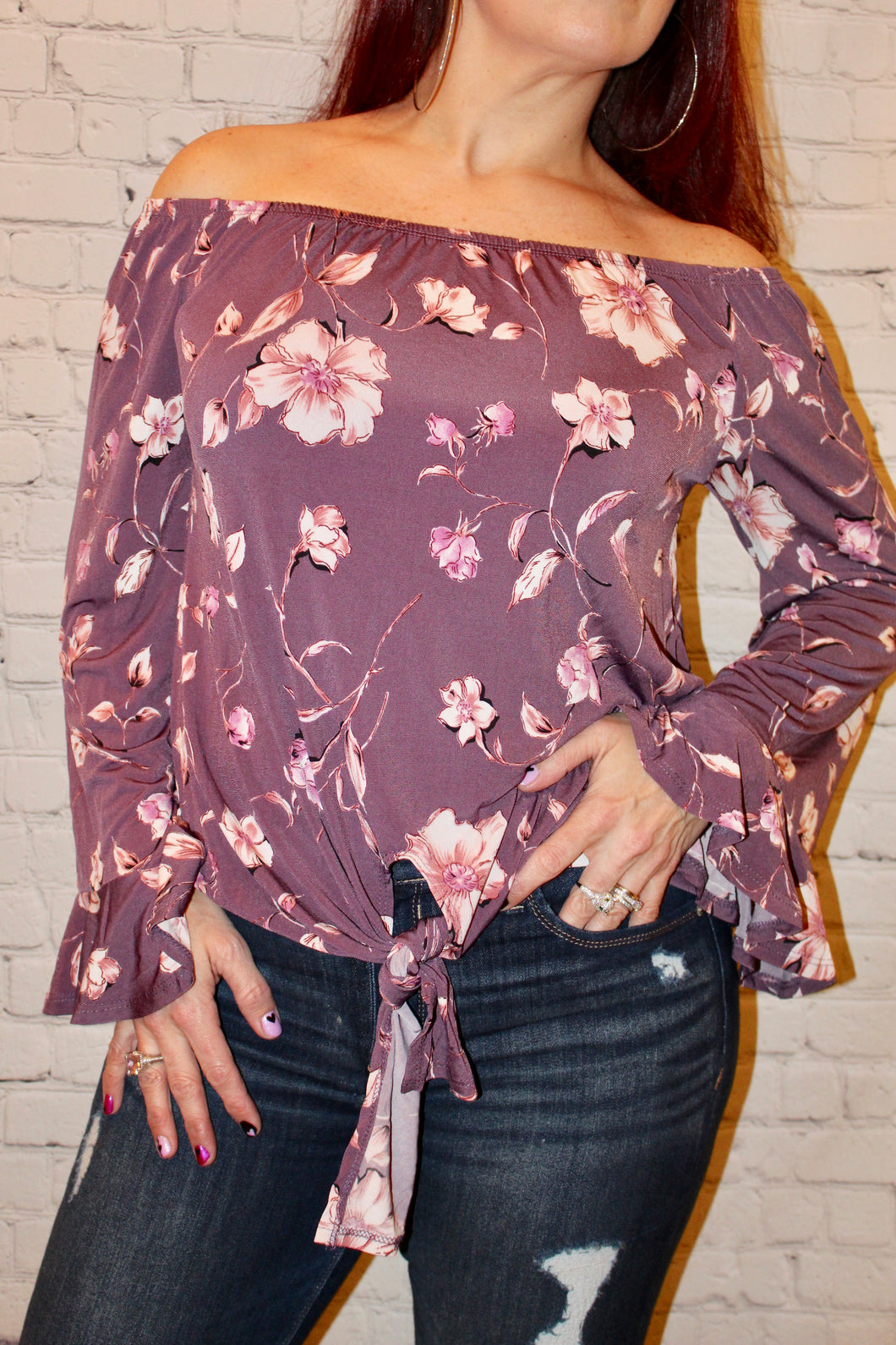 Off the shoulder knit top featuring ruffled bell sleeves and front self-tie knot